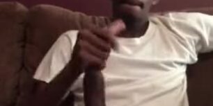 Horny black strokes his fat long cock in the living room