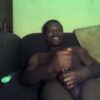 Horny black dad stroking his beefy fat cock solo on his sofa