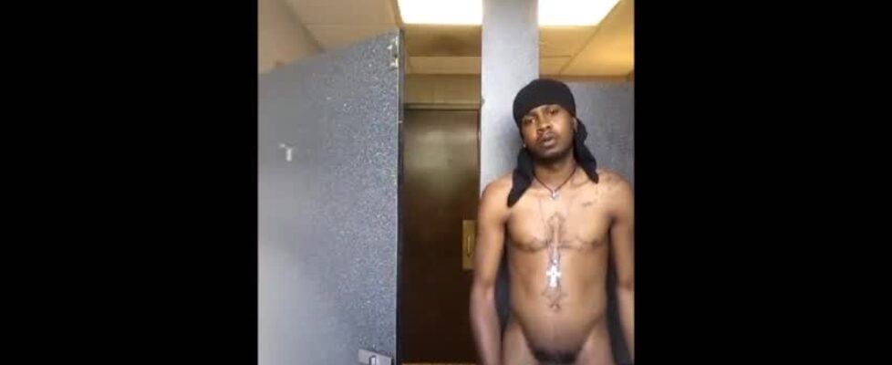 Horny black guy stroking his cock in public bus station