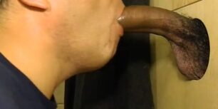 Sucking off a young black cock thru a glory hole