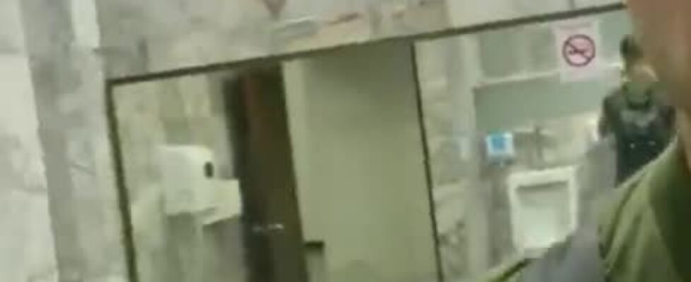 Handsome hung rubbing his cock in a public bathroom